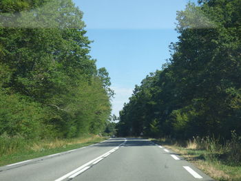 Road amidst trees against sky