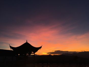Silhouette built structure against sky during sunset