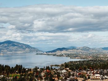 High angle view of city by lake against sky