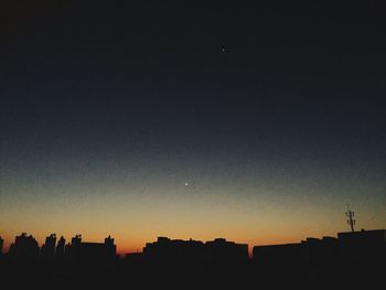 Low angle view of silhouette buildings against sky at sunset