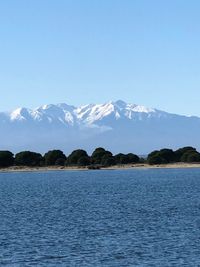 Scenic view of lake and snowcapped mountains against sky