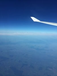 Aerial view of airplane wing against clear blue sky