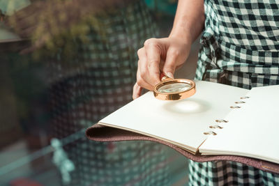 Midsection of man holding coffee cup on table