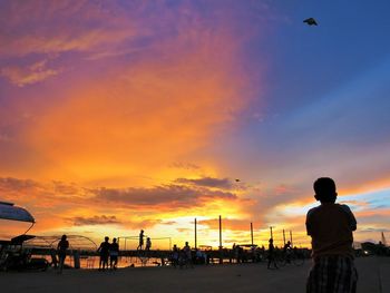 Silhouette of man at beach against sky during sunset