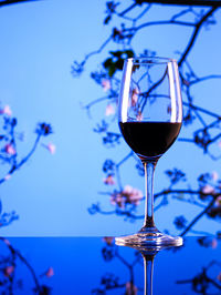 Close-up of wine glass against blue sky