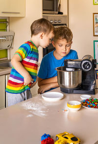 Cute brothers preparing sweet dish at kitchen