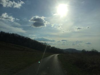 Road amidst trees against sky