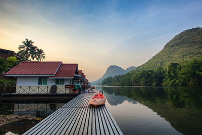 Scenic view of lake by buildings against sky