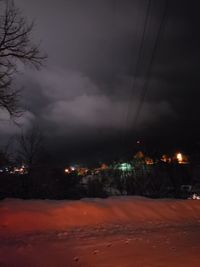 Illuminated city against sky at night