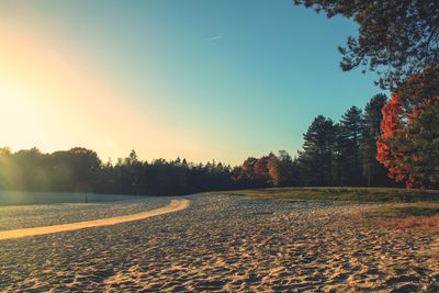 Scenic view of land against clear sky during sunset