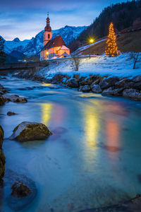 Illuminated buildings against sky during winter