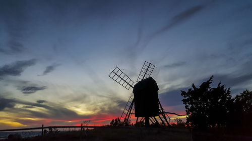 Silhouette traditional windmill against sky at sunset