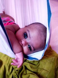 Portrait of cute baby lying on bed