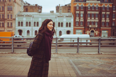Portrait of young woman with scarf on the city street