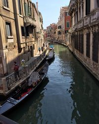 Boats in canal along buildings