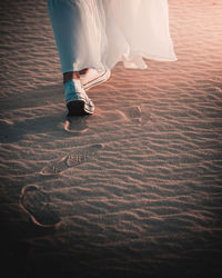Low section of woman walking at desert