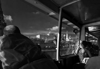 People in ferry boat over moskva river against sky
