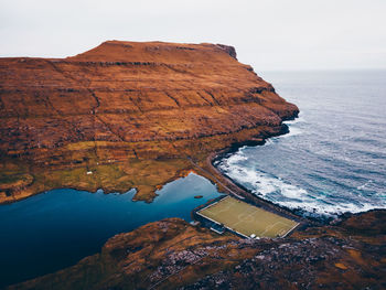 Scenic view of rock formations by sea against sky