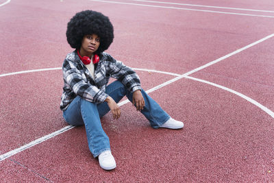 Afro woman sitting on sports court