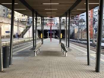 Empty footpath amidst buildings in city