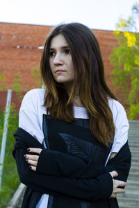 Woman looking away while standing in city