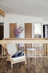 Senior man repairing sconce at home