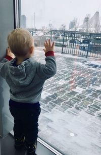 Rear view of boy standing on snow