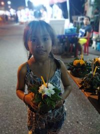 Full length of girl standing by flowering plants