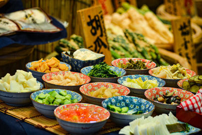 High angle view of pickles in multi colored bowls on table