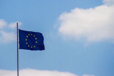 Low angle view of flag against blue sky