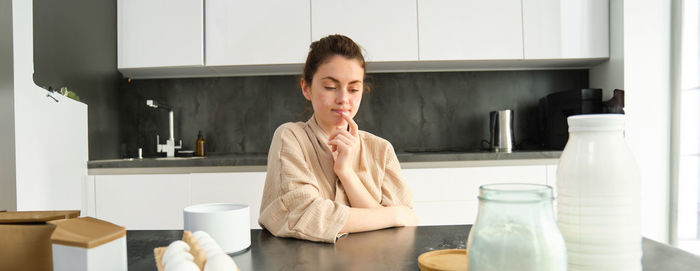 Portrait of young woman sitting in bathroom