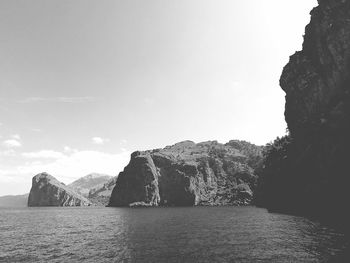 Rock formations by sea against sky