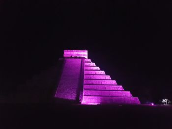 Low angle view of illuminated steps against sky at night