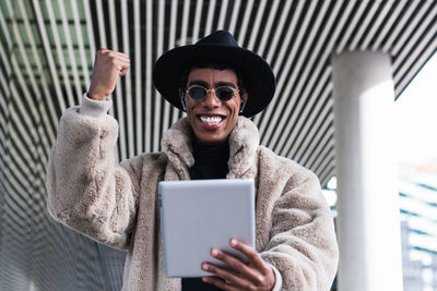 Portrait of smiling young man using mobile phone