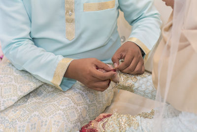 Midsection of couple holding hands