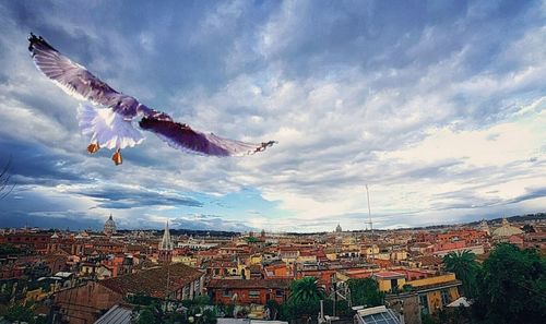 View of cityscape against cloudy sky