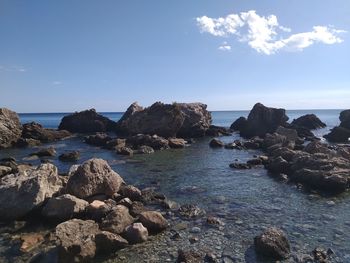 Rocks on beach against sky