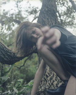 Portrait of woman against tree