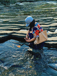 Woman photographing lake with smart phone