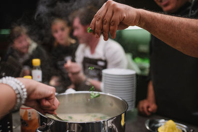 Midsection of people preparing food outdoors