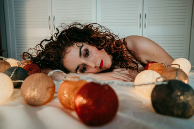 Portrait of young woman lying on table at home