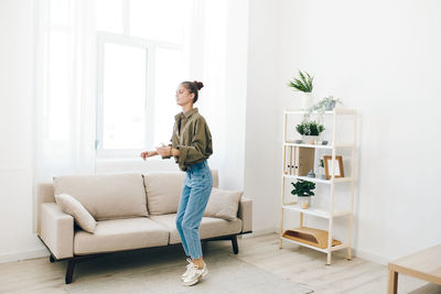 Young woman using laptop while sitting on sofa at home