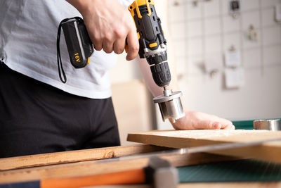 Home workshop. close-up of a man in goggles working with a drill.