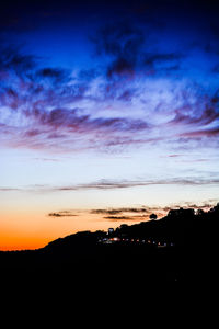 Silhouette landscape against sky at sunset