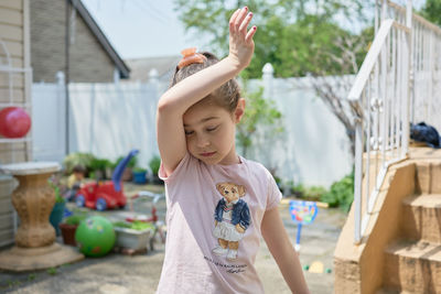 Cute young girl playing in the backyard on a sunny day