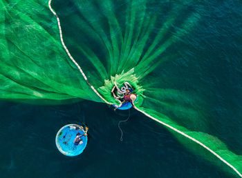 Drone shot of fisherman putting fishing net in sea