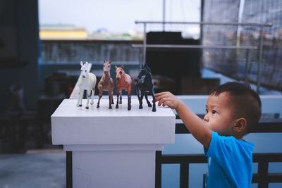 Boy holding toy on table