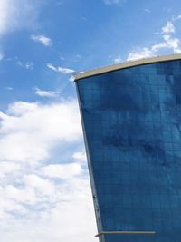 Low angle view of glass building against sky