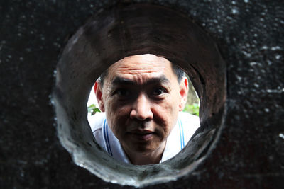 Close-up portrait of man seen through hole