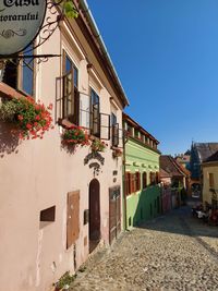 Street amidst buildings against blue sky